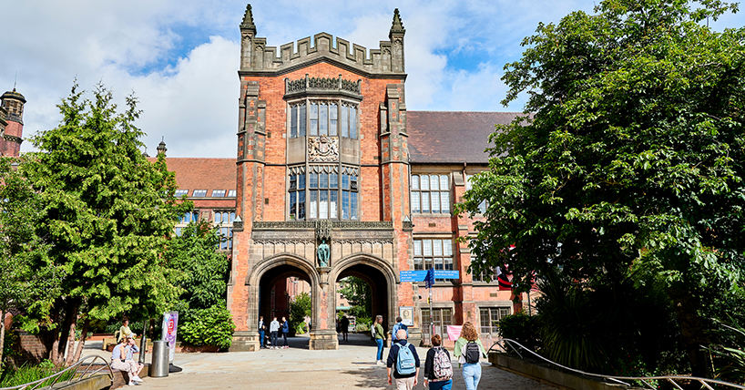 The red brick Arches of Newcastle University in the sunshine with people walking through